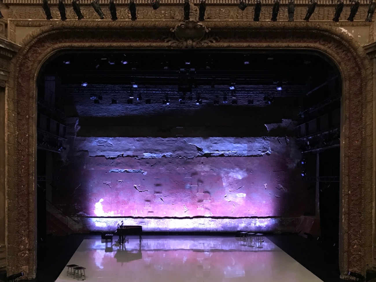 The open stage at the Brooklyn Academy of Music right before the world premiere of Meredith Monk’s Cellular Songs, empty but for four stools and a piano in the corners